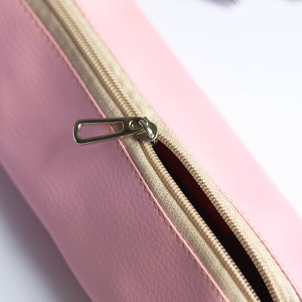 Estojo personalizado feito em tecido sintético com textura que imita couro cor rosa claro detalhe do zíper